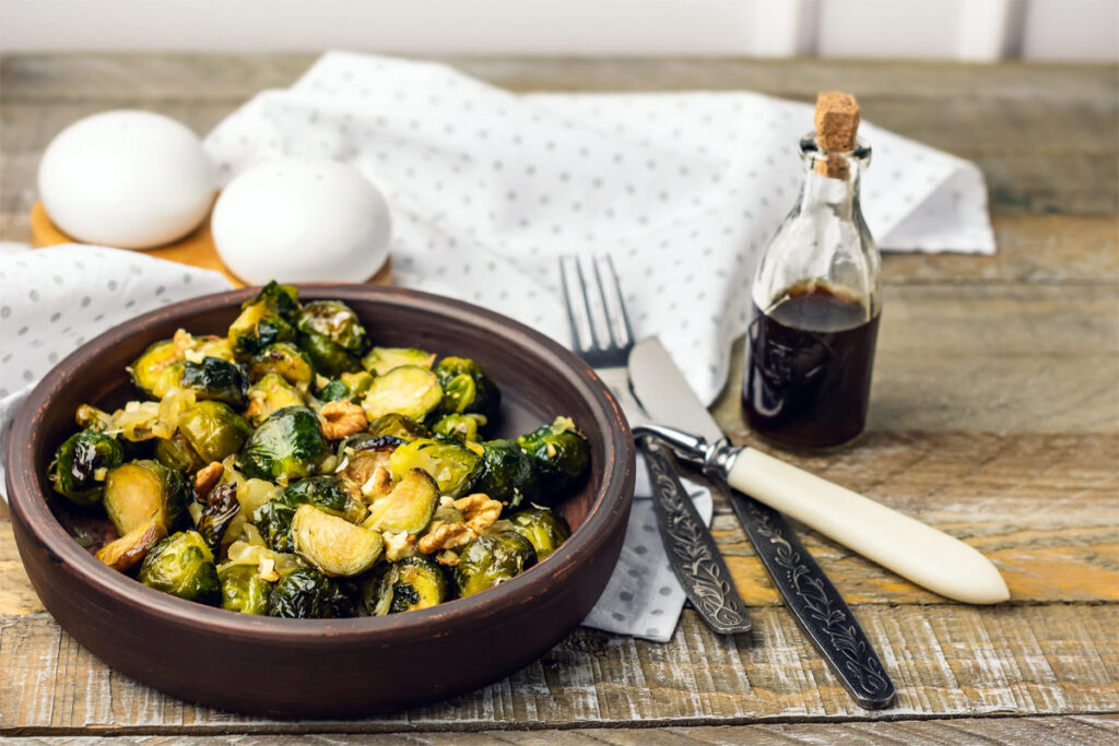 Rosenkohl, gekocht und mit Walnüssen auf einem Teller.