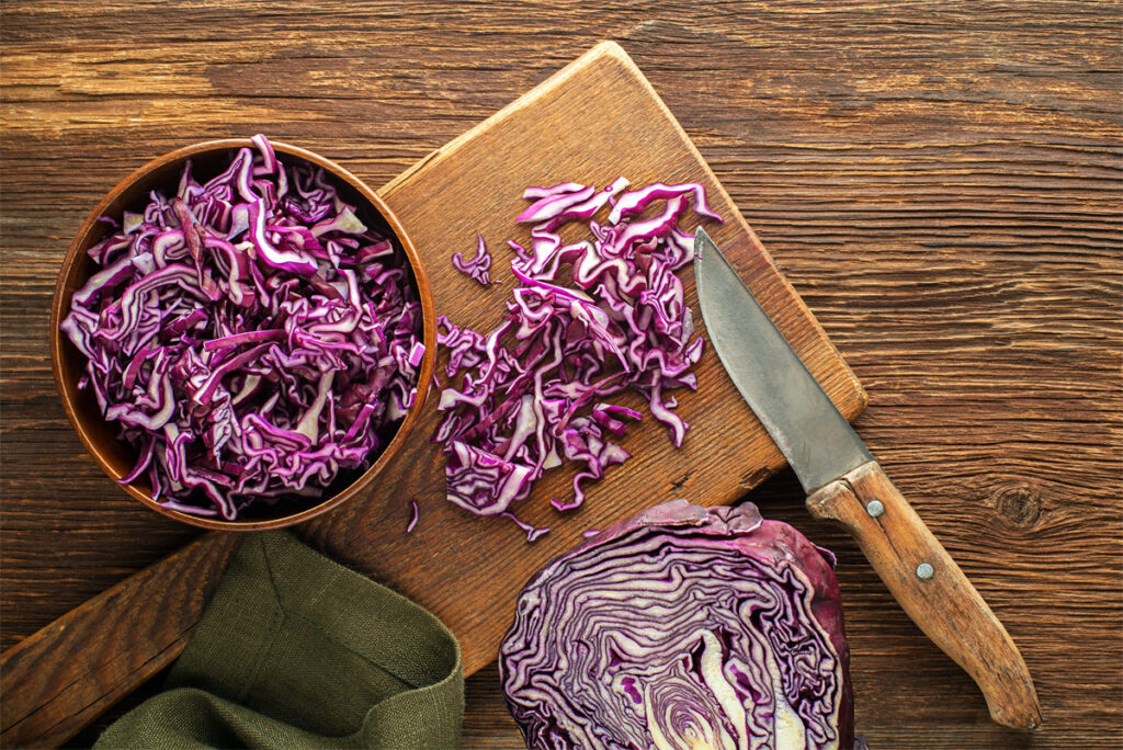 geschnittenes Rotkohl mit Messer auf einem Brett