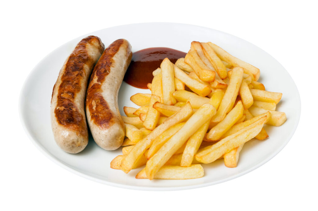 Ein Teller mit Bratwurst, Pommes und Ketchup