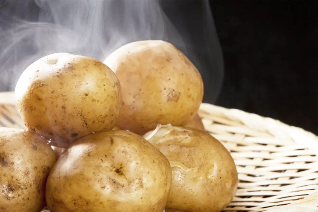 dampfende Kartoffeln auf einem Teller und wie lange Kartoffeln kochen