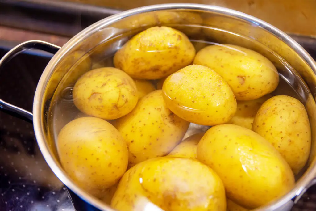 Kartoffeln mit Wasser in einem Topf. Wie lange Kartoffeln kochen.