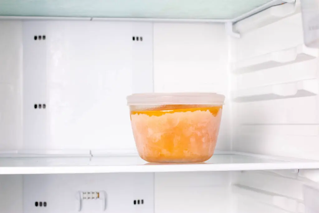 eingefrorene Kürbissuppe in einer Vorratsdose. Kürbissuppe im Kühlschrank.