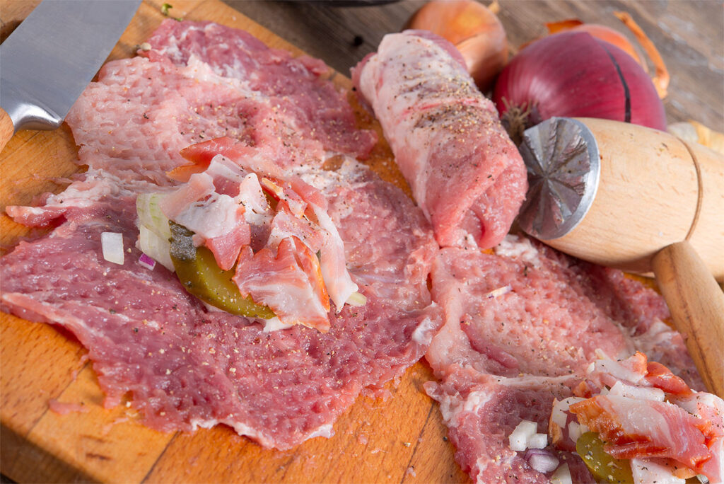 Rindsroulade mit Speck und Zwiebeln füllen.