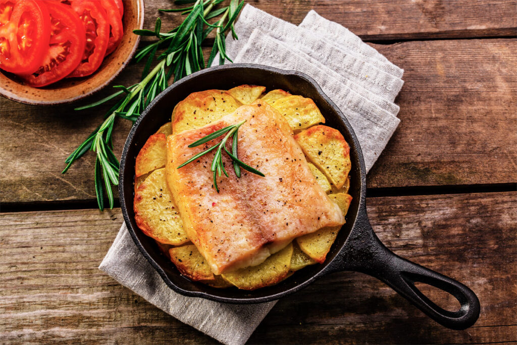 Flammlachs mit Kartoffeln in einer Pfanne