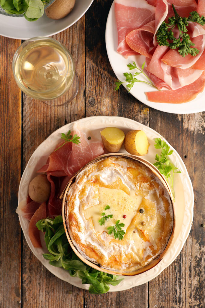 Ofenkäse mit Schinken und Kartoffeln als Beilagen