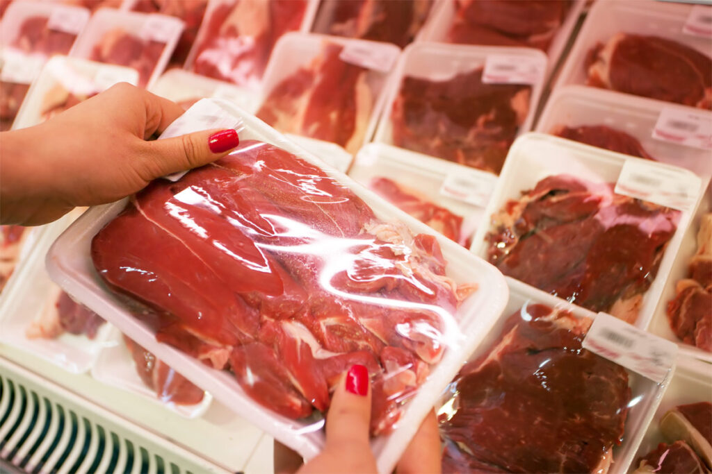 Frau hat Rindfleisch verpackt in der Hand