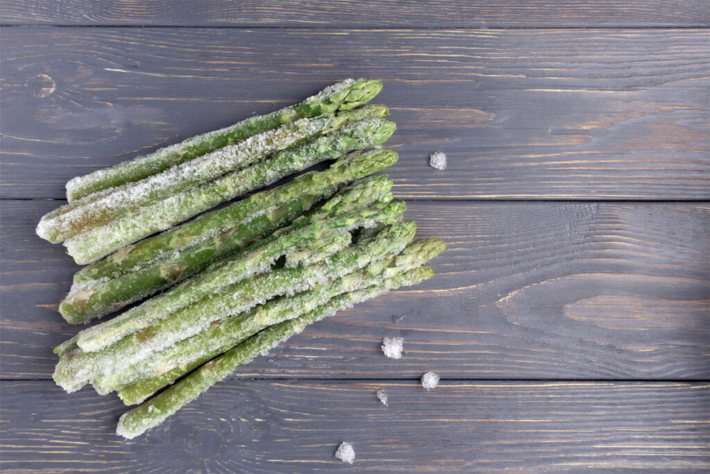 Eingefrorener Spargel auf einem Holzbrett