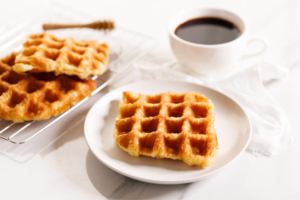 Teller mit Waffeln ohne Milch mit einer Tasse Kaffee