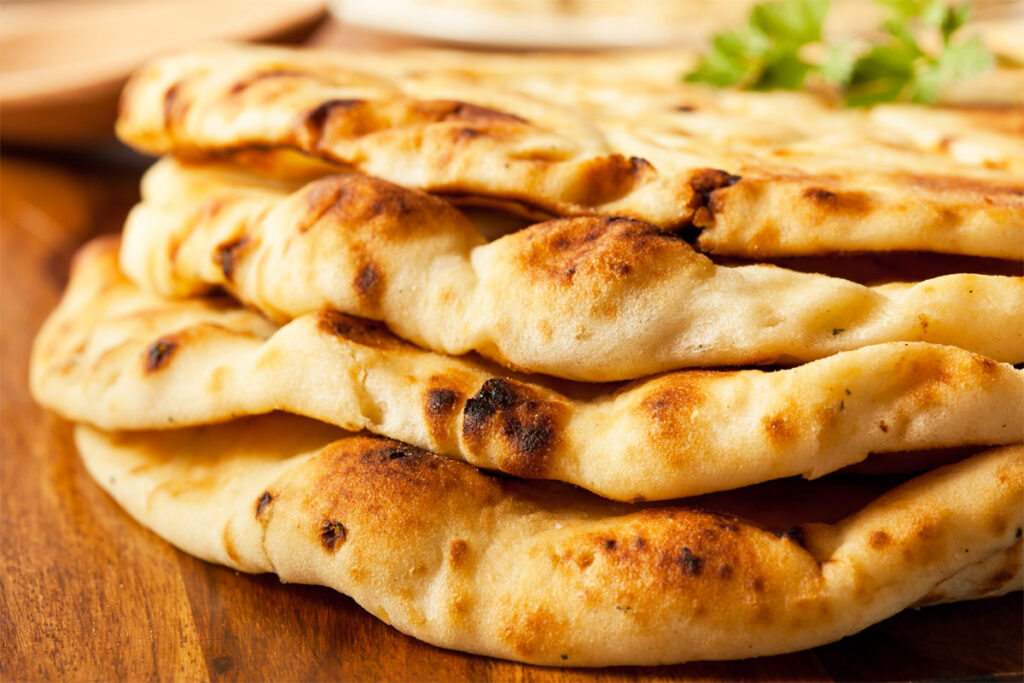 vier Stück Naan-Brot übereinander gelegt auf einem Tisch