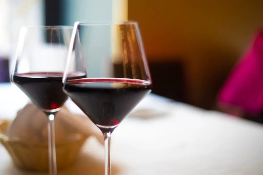 zwei halbvolle Weingläser mit Rotwein