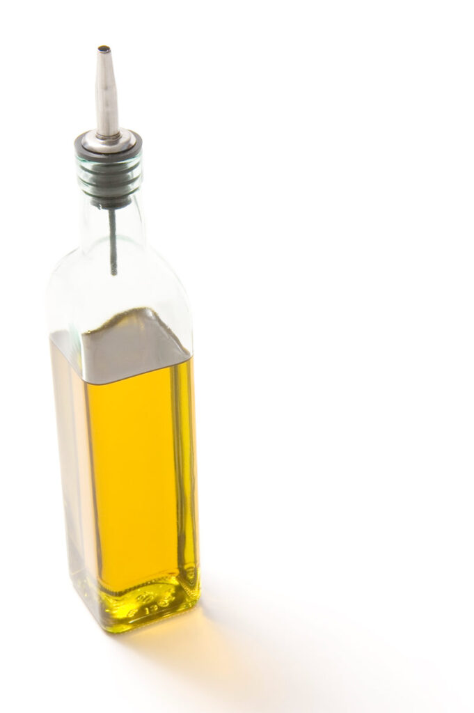 Eine Glasflasche mit Olivenöl.