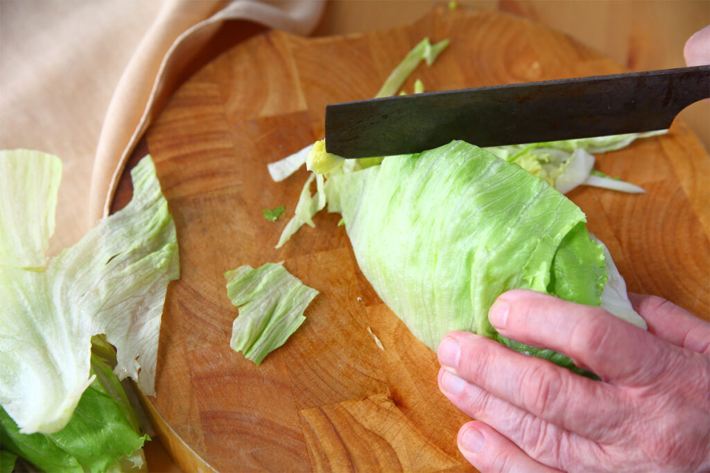 Eisbergsalat in die passende Größe schneiden