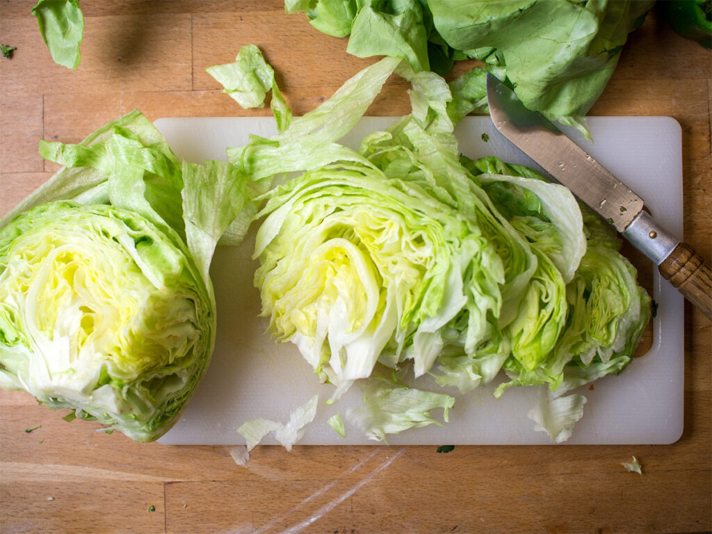 Eisbergsalat halbiert liegt auf einem Brett