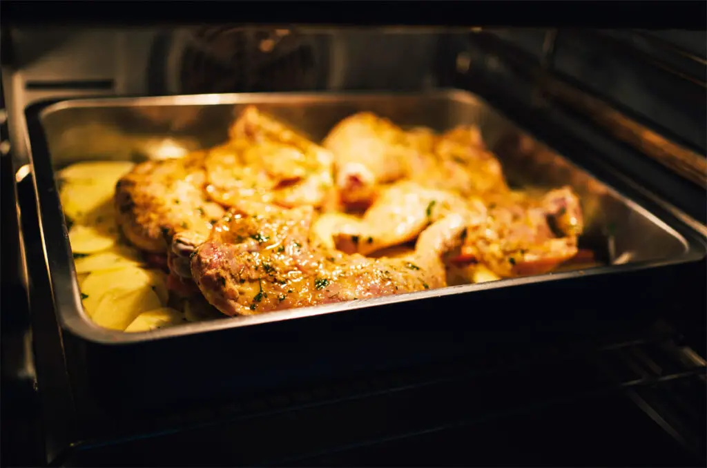 Im Ofen Hähnchenbrust mit Kartoffeln werden gar.